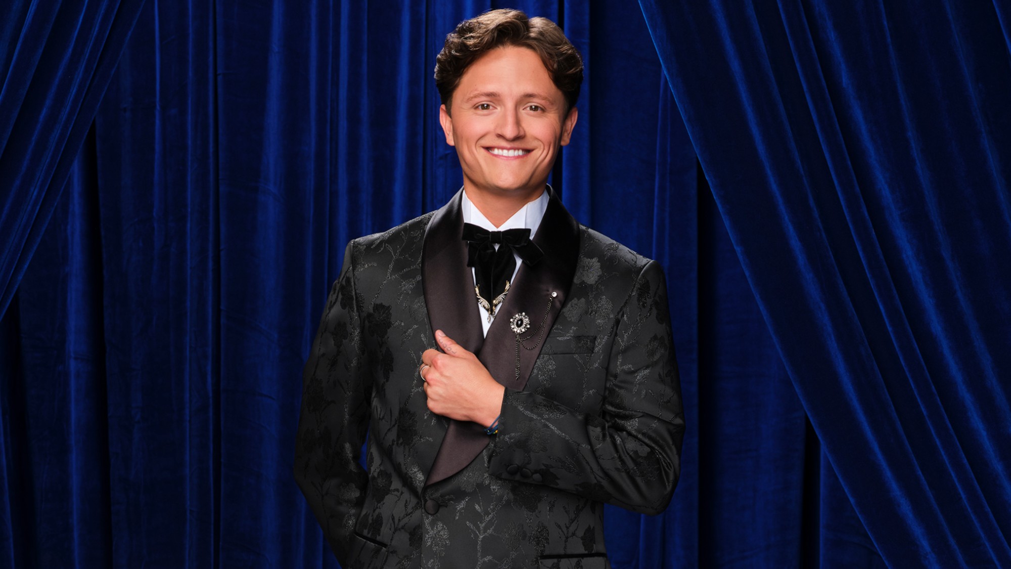 Connor Wood holding his jacket with his right hand in DWTS shoot.