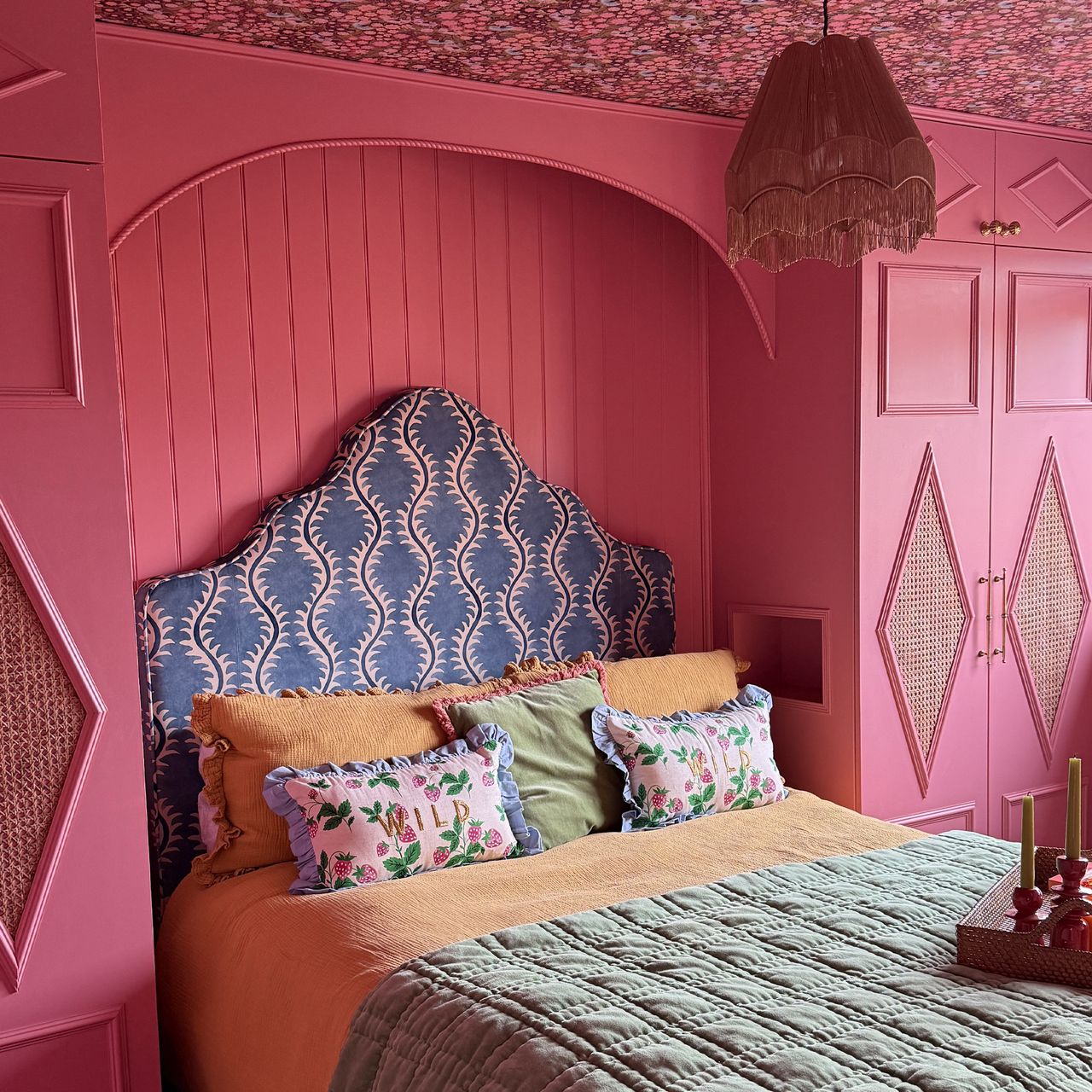 The dark pink bedroom of interior designer Roisin Quinn, with an upholstered ottoman bed from Button &amp; Sprung