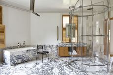 marble bathroom with blue veining bath tub and statement shower