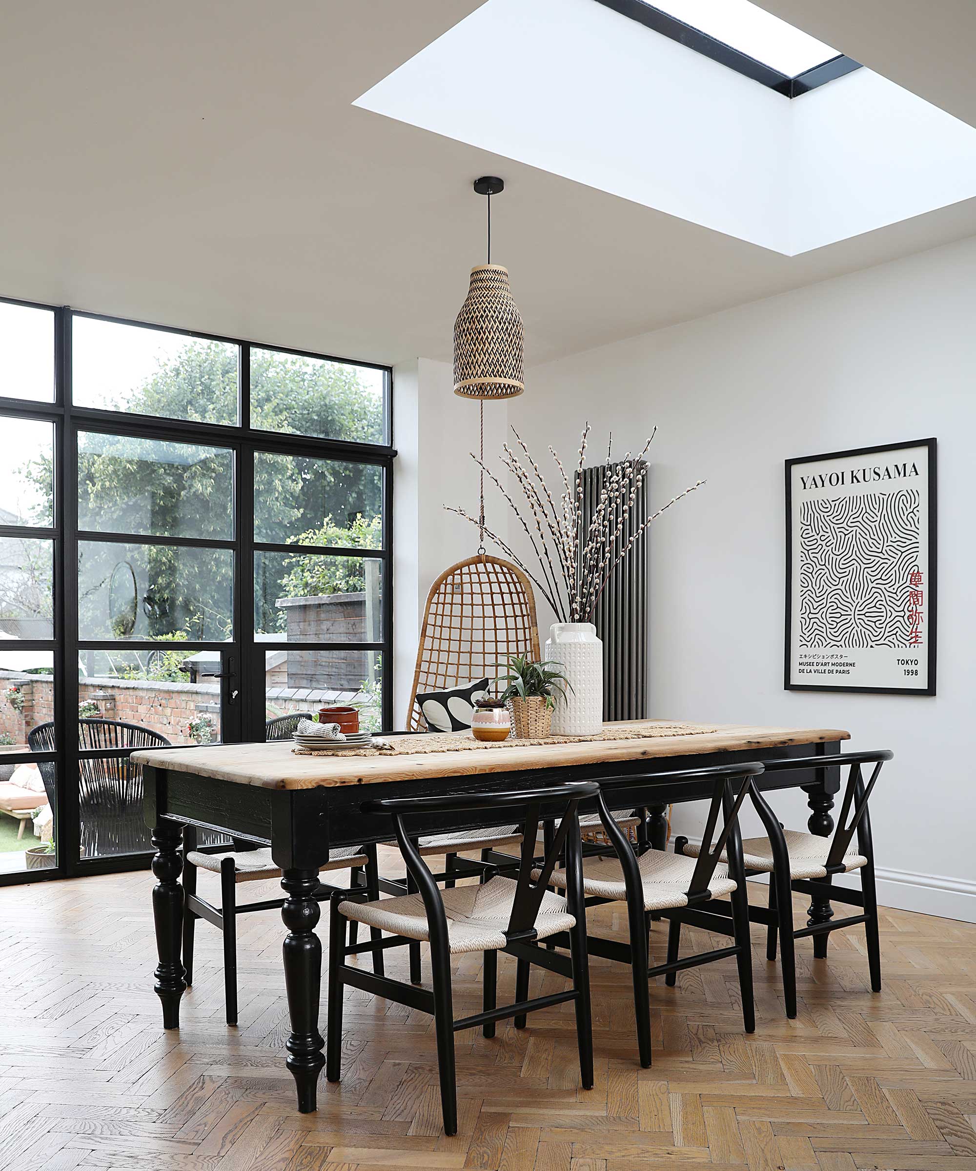 wooden dining table and chairs in a kitchen extension with Crittal-style doors to the garden