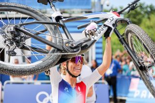 Pauline Ferrand Prevot lifts her bike after winning the Olympic MTB