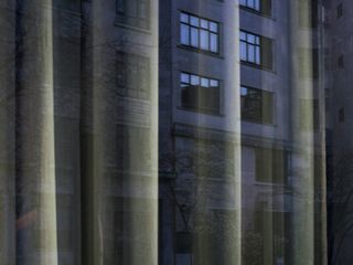 View through net curtains to a dark building