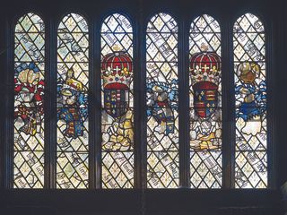 Domestic glass of the 1440s by royal glazier John Prudde at Ockwells, Berkshire. It includes mottos and the device of crossed distaffs, an emblem of service to the Queen