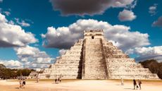 A Maya pyramid in Mexico that includes tourists in the foreground. 