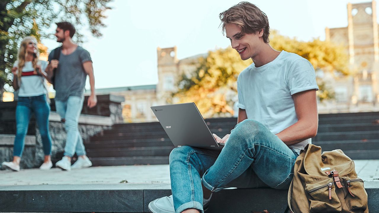 Man using Chromebooks while sat on steps