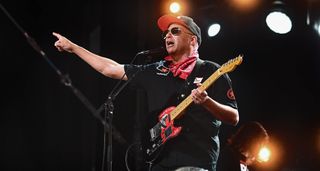 Tom Morello wears shades and a ballcap as he performs with a Tele at a festival.