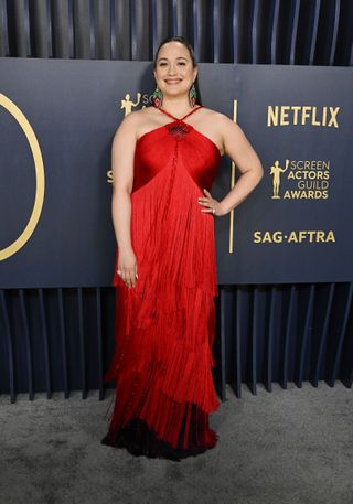 Lily Gladstone arrives at the 2024 SAG Awards in a red fringe dress