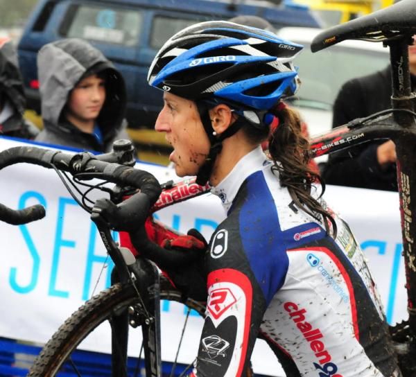 Rebecca Wellons (Team Plan C) shouldering her bike