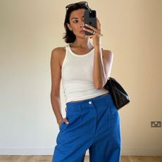 Woman in white tank top and blue pants