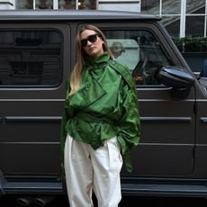 @annelauremais wearing a green Burberry cropped trench coat with white pants.