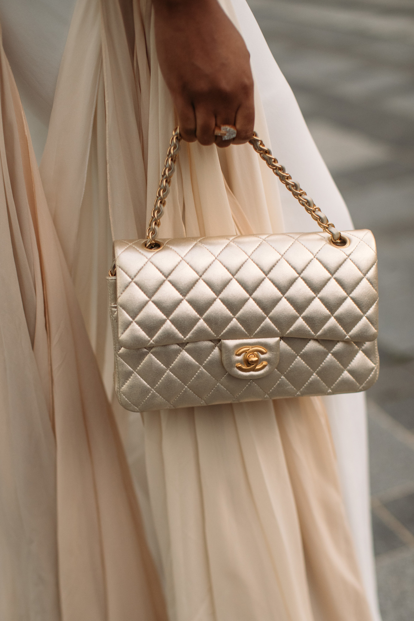 a woman carrying a chanel flap bag in Paris
