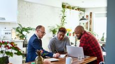 Couple listening to financial advisor at home with laptop