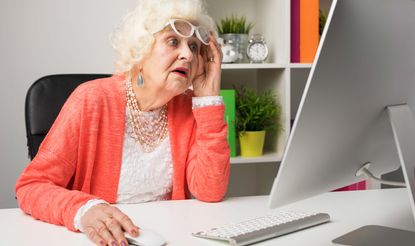 A grandma looks at her computer in dismay.