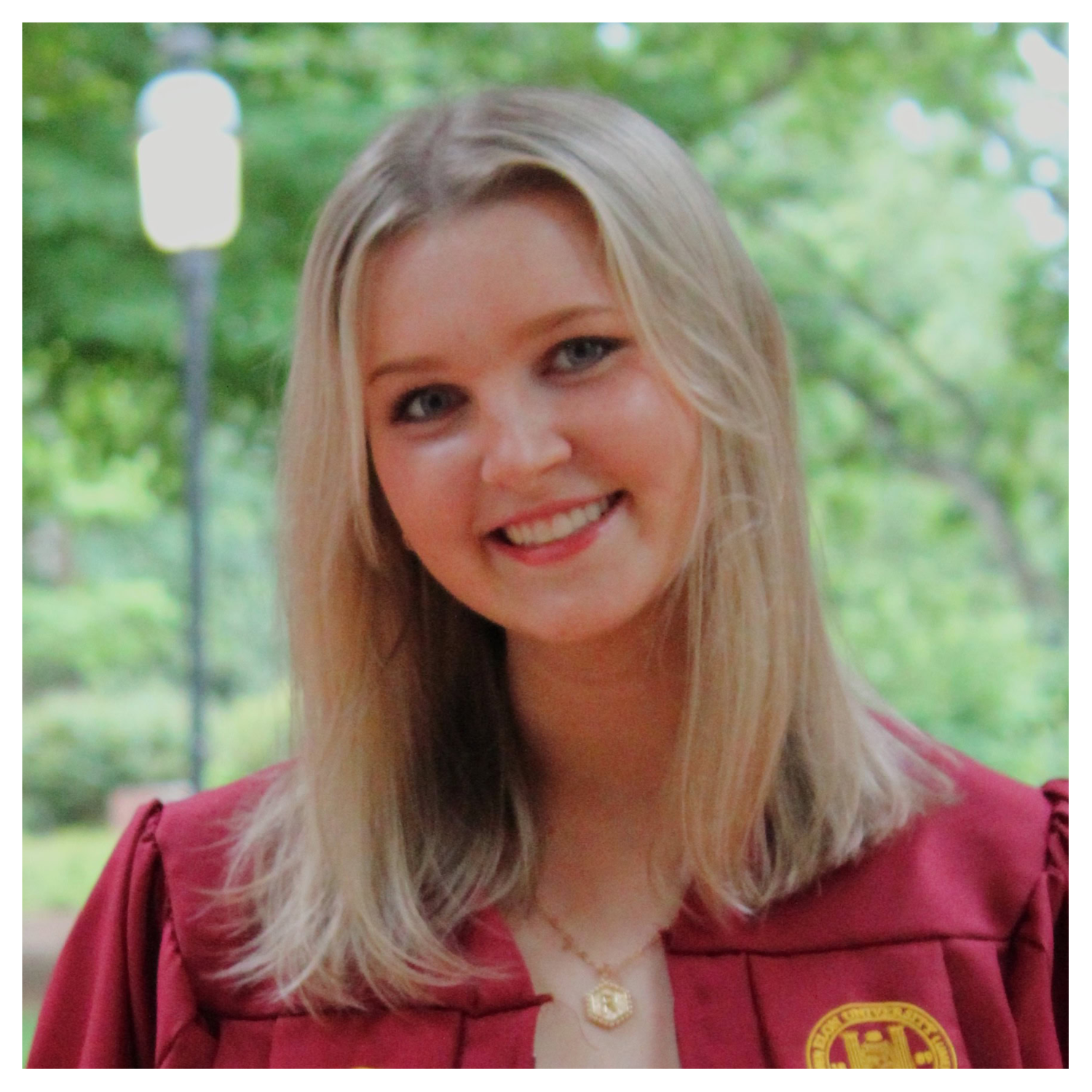 A headshot of a girl in a red graduation gown