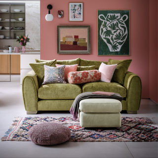 olive sofa in a living room with colourful sofa cushions and throw on foorstool