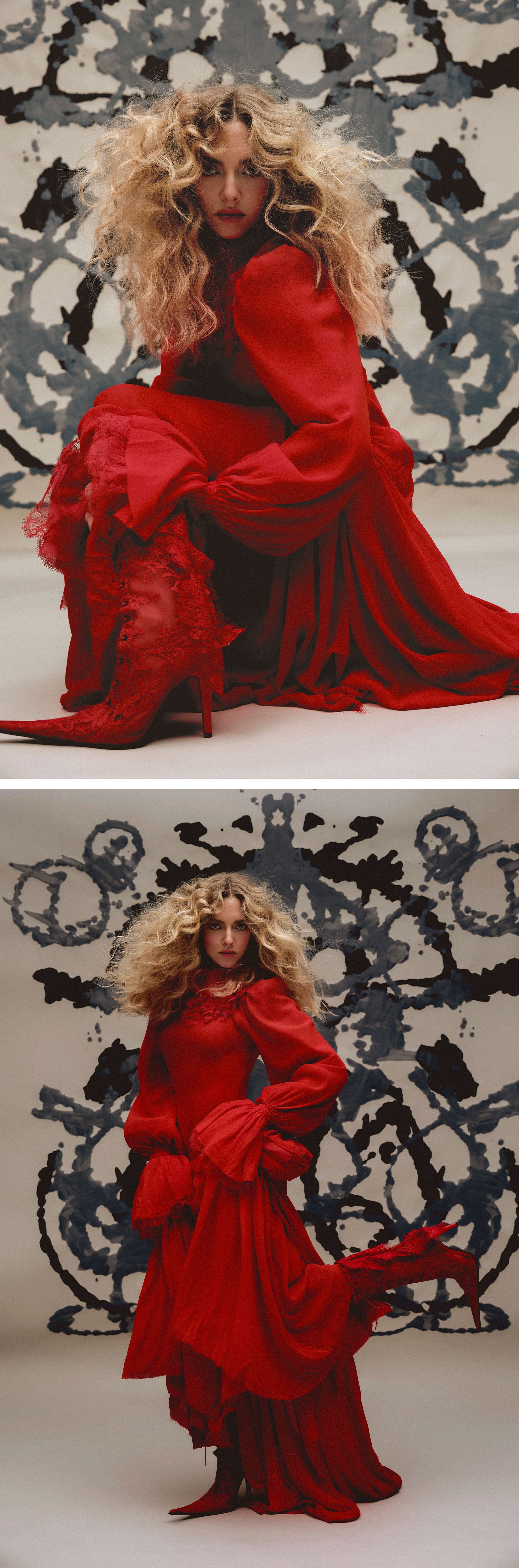 Amanda Seyfried for Who What Wear's December cover story. Top image: She is photographed kneeling down showing off her red lace pointed-toe boots peeking out of her McQueen red dress with billowy sleeves. Her hair is voluminous and curly, and she is in front of a painted backdrop. Bottom image: Wearing the same look, she is photographed with her left leg kicked back.