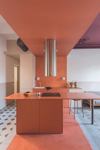A kitchen with a terracotta toned island