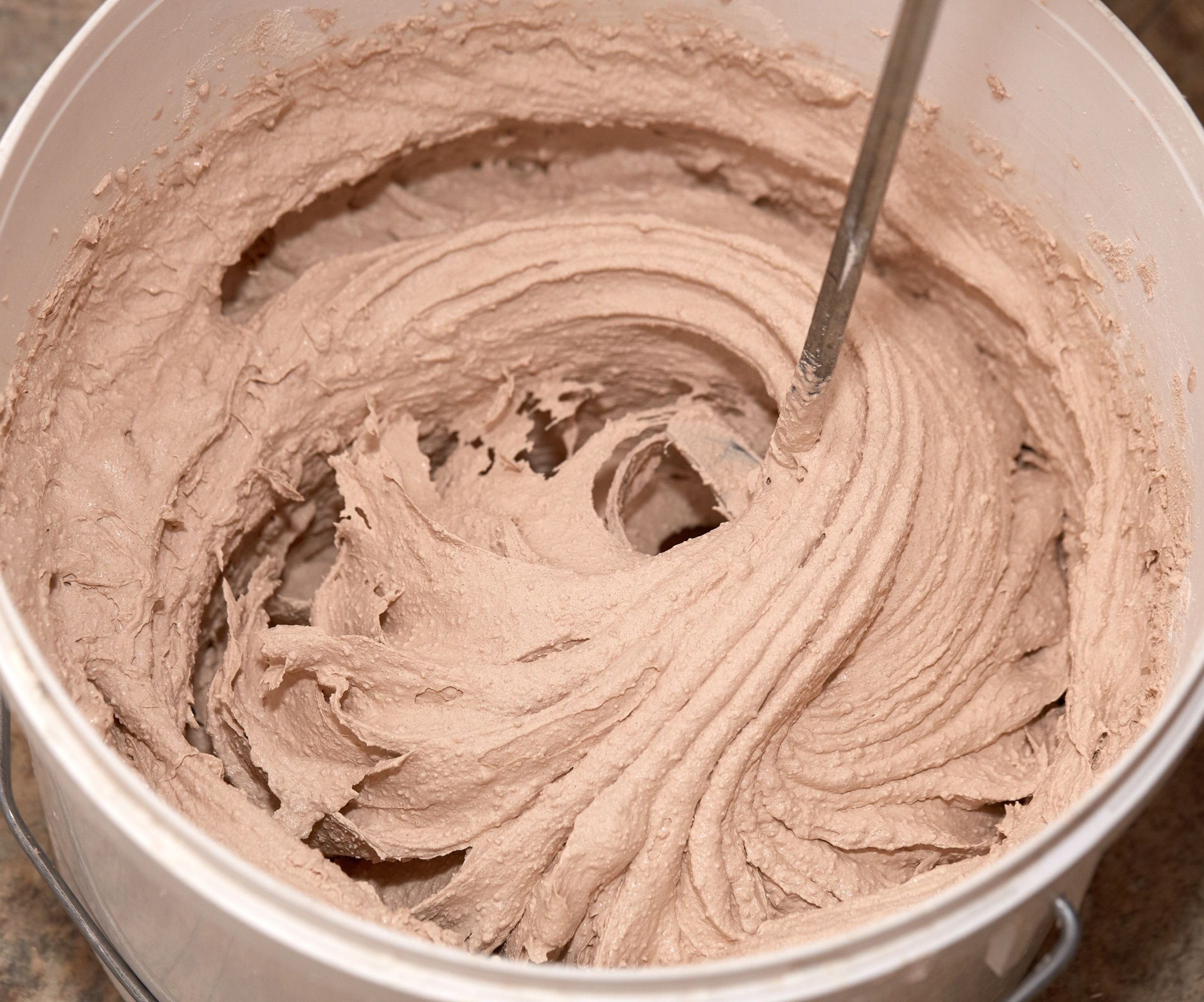 Plaster being mixed in a white plastic tub