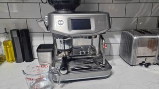 Coffee maker with jug of vinegar beside it