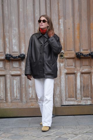 Woman in white jeans and leather jacket