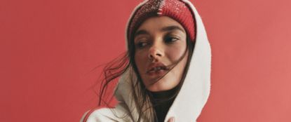 Woman in white hoodie and red beanie