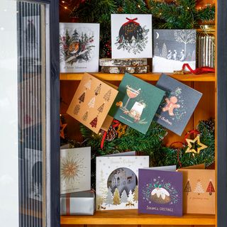 Christmas cards on wooden shelves in a display cabinet