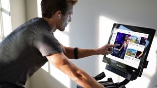 Man selecting an iFit workout on the NordicTrack S22i Studio bike