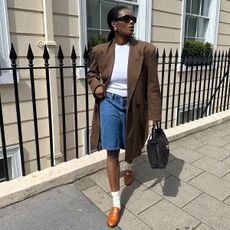 best elevated basics shown in a photo of a woman wearing a brown blazer over a white t-shirt with denim shorts 