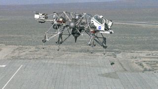 a prototype lunar lander vehicle in the air above a desert