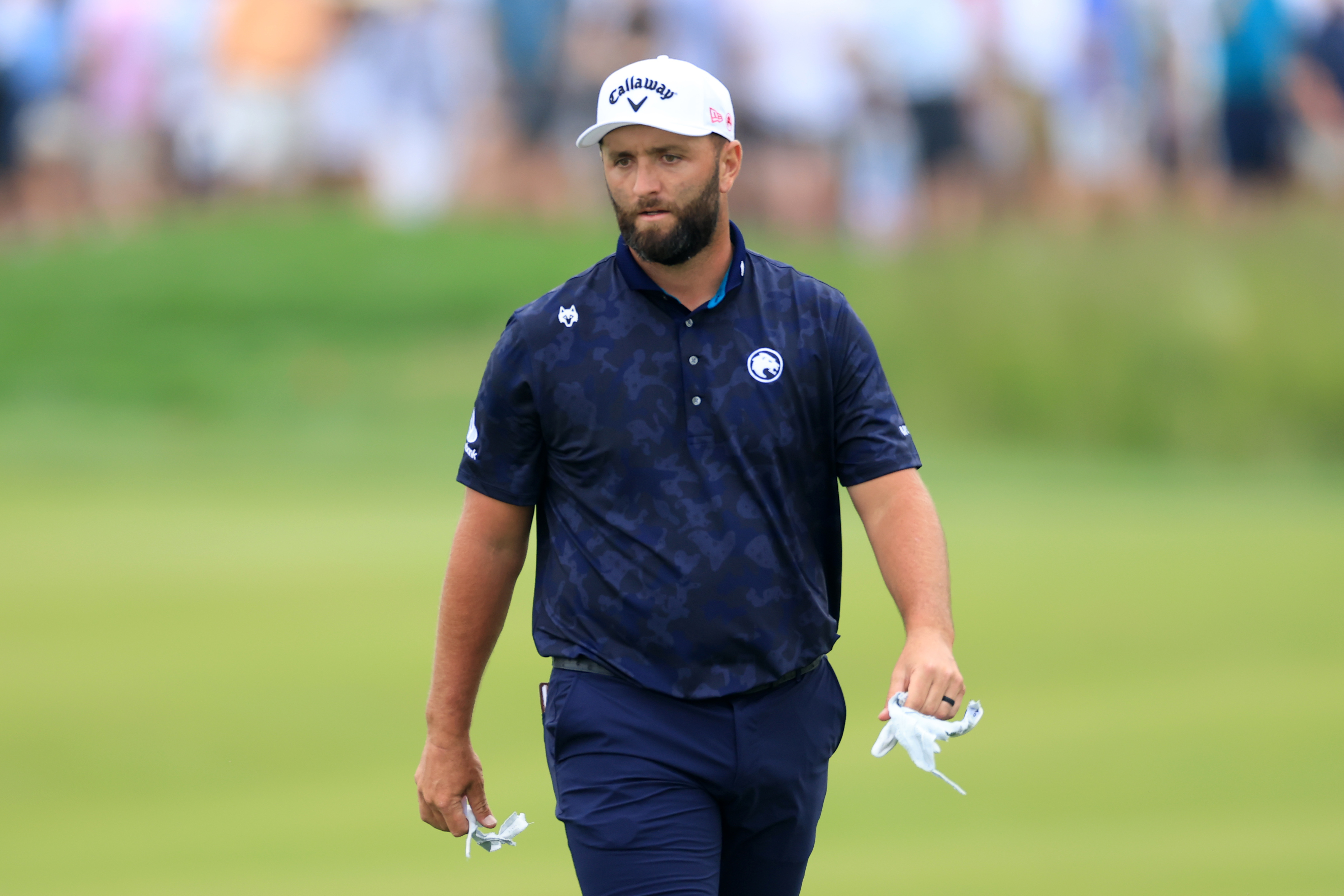Jon Rahm walks off the green frustrated