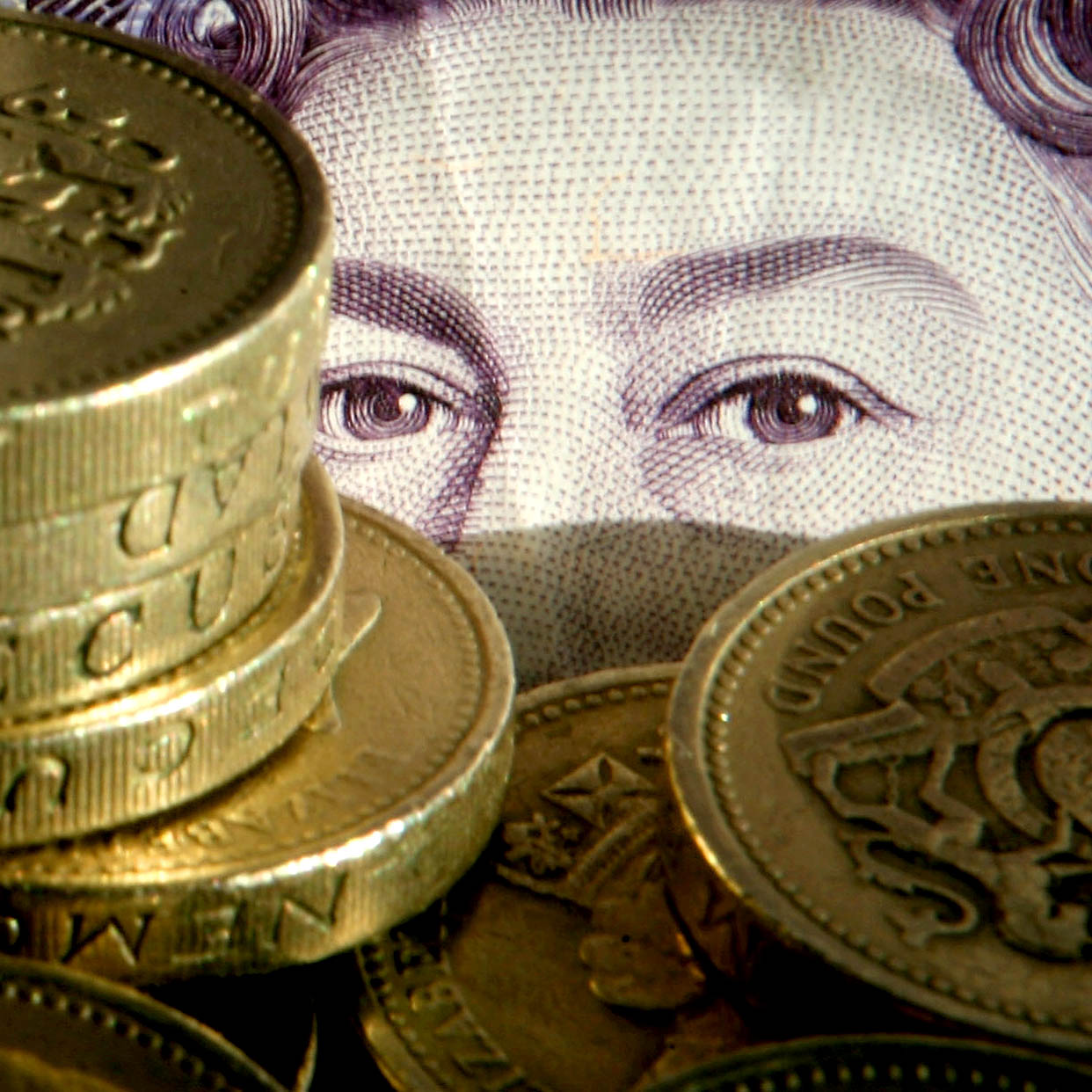BRISTOL, UNITED KINGDOM - NOVEMBER 27:In this photo illustration pound coins are stacked in front of a twenty pound note on November 27 2008 in Bristol, England. Many UK consumers are feeling