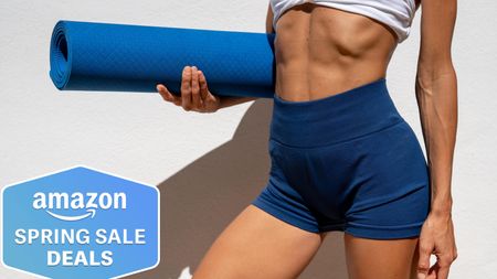 Woman holding a blue yoga mat wearing workout gear showing torso and legs only, Amazon Spring Sale badge bottom left