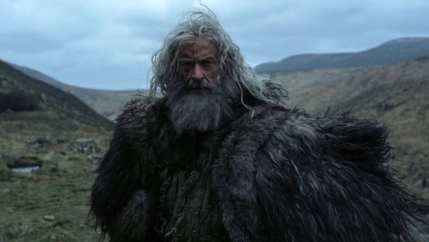 Robin Hood with long stingy hair and a long beard, dressed in furs, as Robin Hood