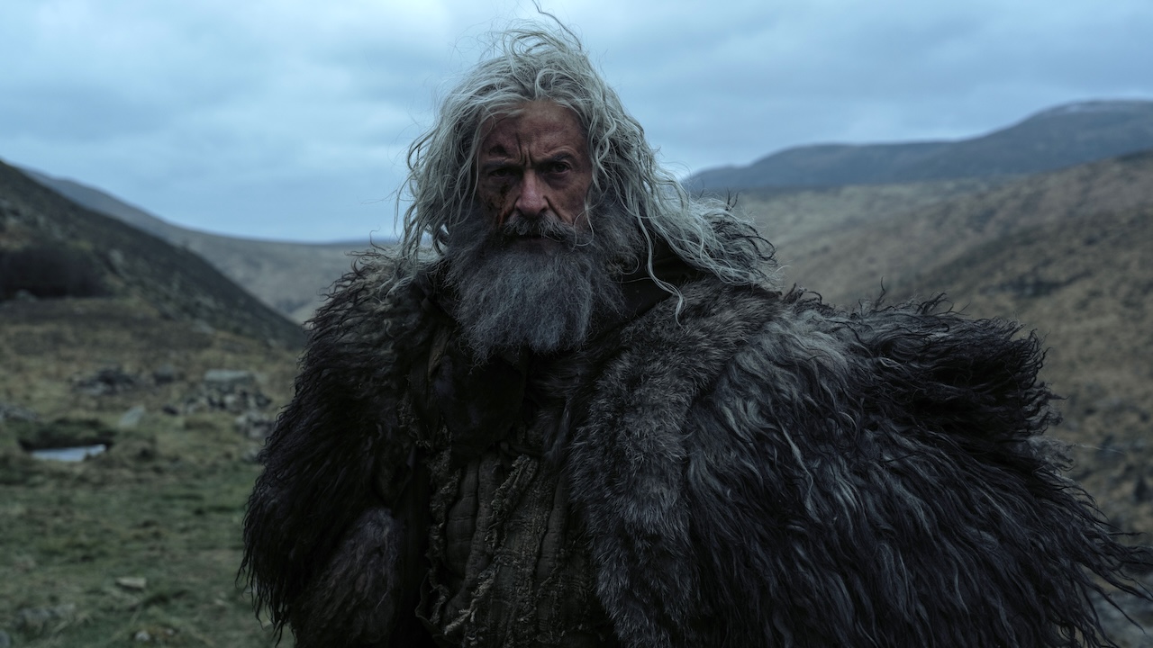 Robin Hood with long stingy hair and a long beard, dressed in furs, as Robin Hood