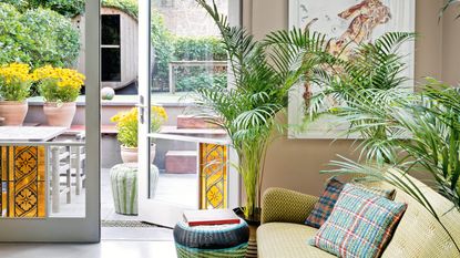 colorful living room with doors with yellow leaded glass, green sofa and colorful wicker stools