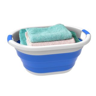 A blue collapsible laundry basket with towels in it