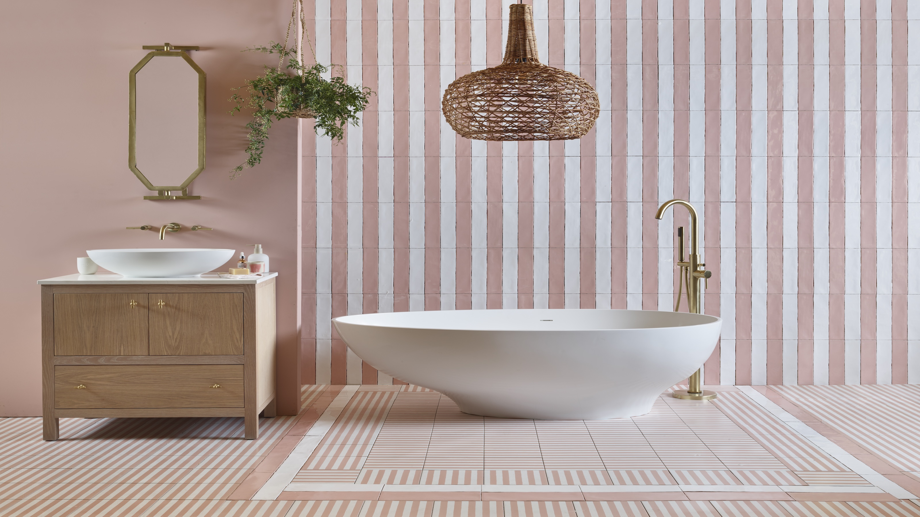 A bathroom with a bathtub a sink and a large light pendant hanging above the tub. 