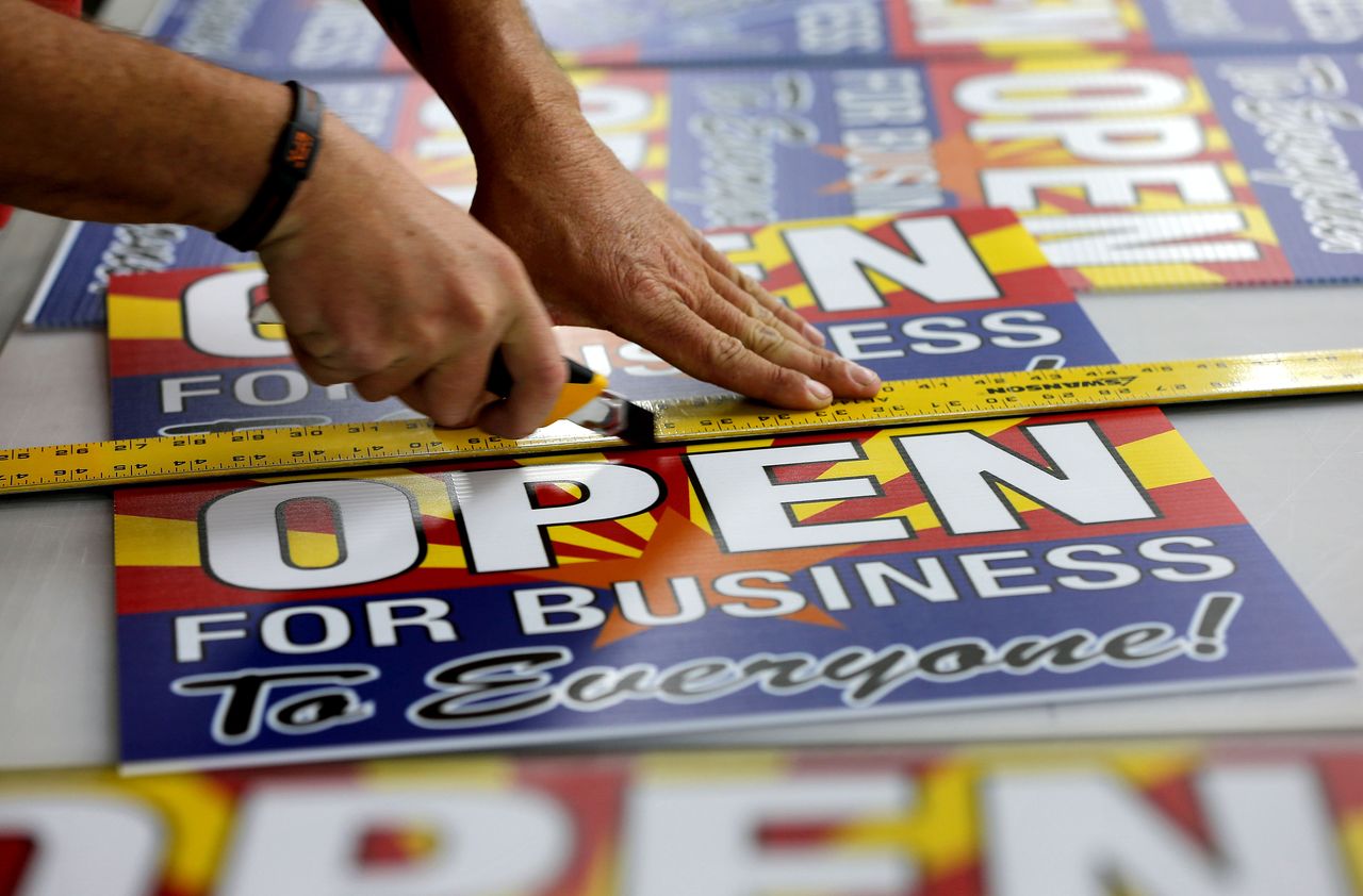 A man cuts out a sign.