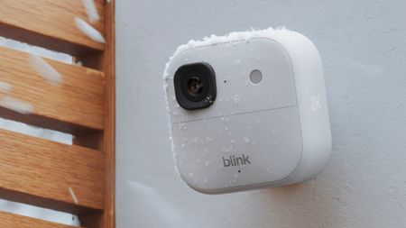 Blink Outdoor 2K+ security camera mounted on wall with raindrops