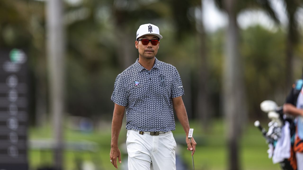 Kevin Na walks along holding his putter and wearing sunglasses during LIV Golf Miami 2025