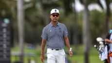 Kevin Na walks along holding his putter and wearing sunglasses during LIV Golf Miami 2025