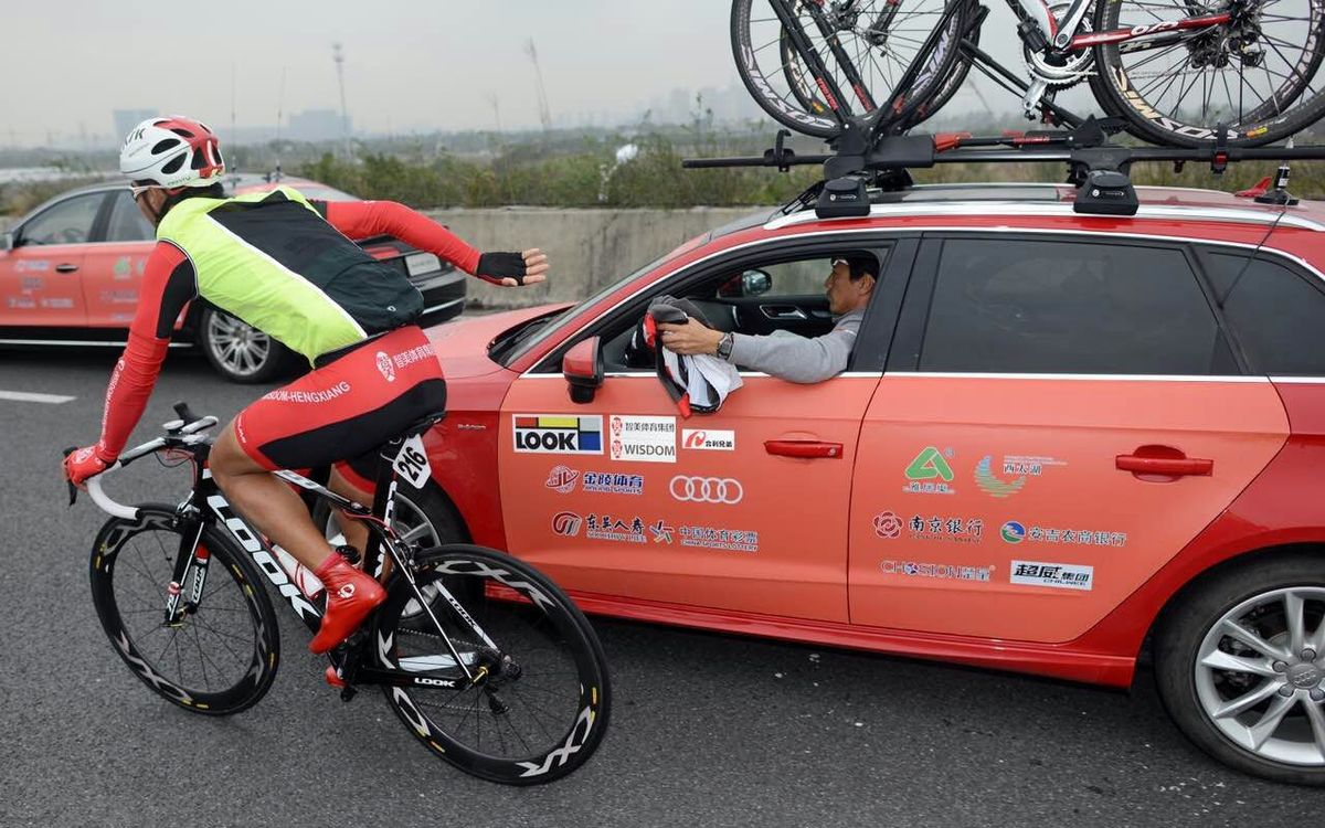 A rider drops back to the team car for an extra layer