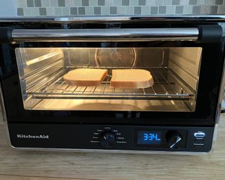 KitchenAid Digital Countertop Oven preparing toast (sliced bread) on wooden countertop