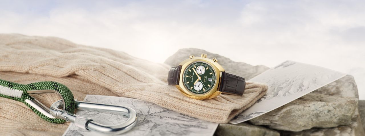 The Certina DS-2 Chronograph in gold, with a green dial, sat on top of some climbing gear