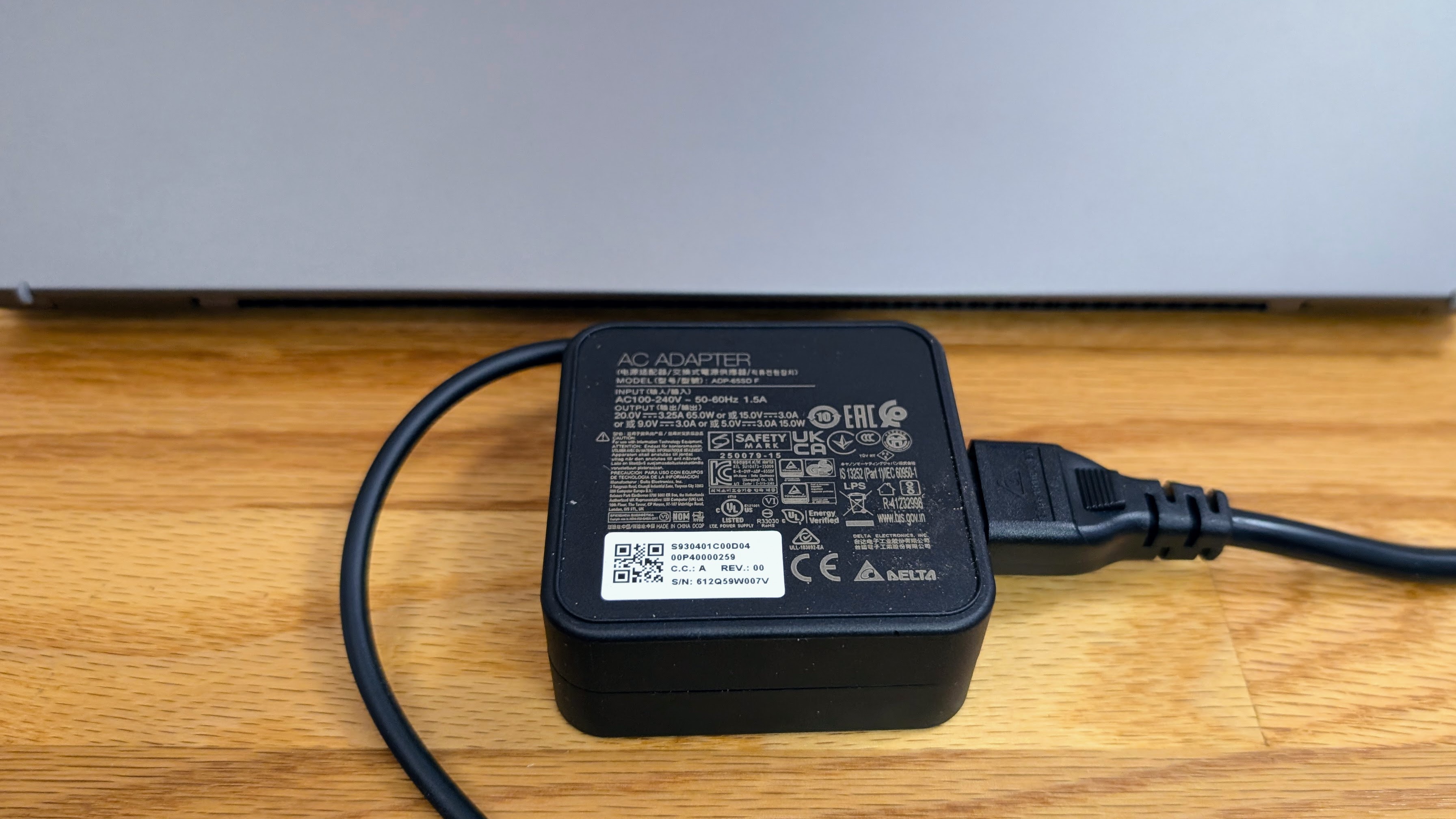 MSI Prestige 14 AI+ close up of included 65W charger next to laptop