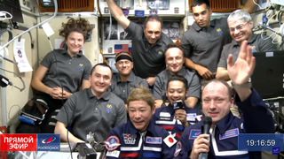 The International Space Station crew poses for a family photo with Japanese space tourists Yusaku Maezawa and his assistant Yozo Hirano.