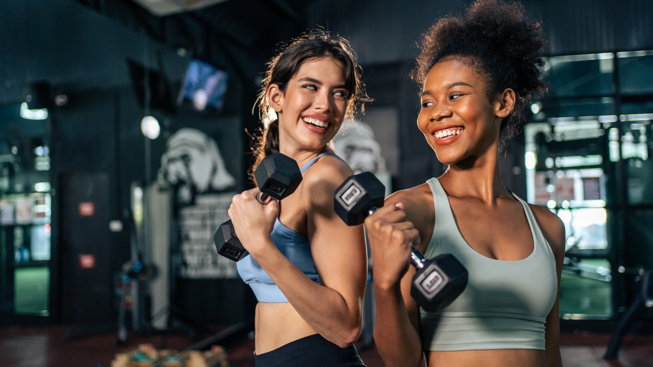 Two women exercising at the gym to beat gym anxiety