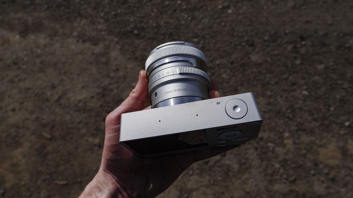 Silver Sigma BF camera with 35mm f/2 DG contemporary lens attached, in the hand