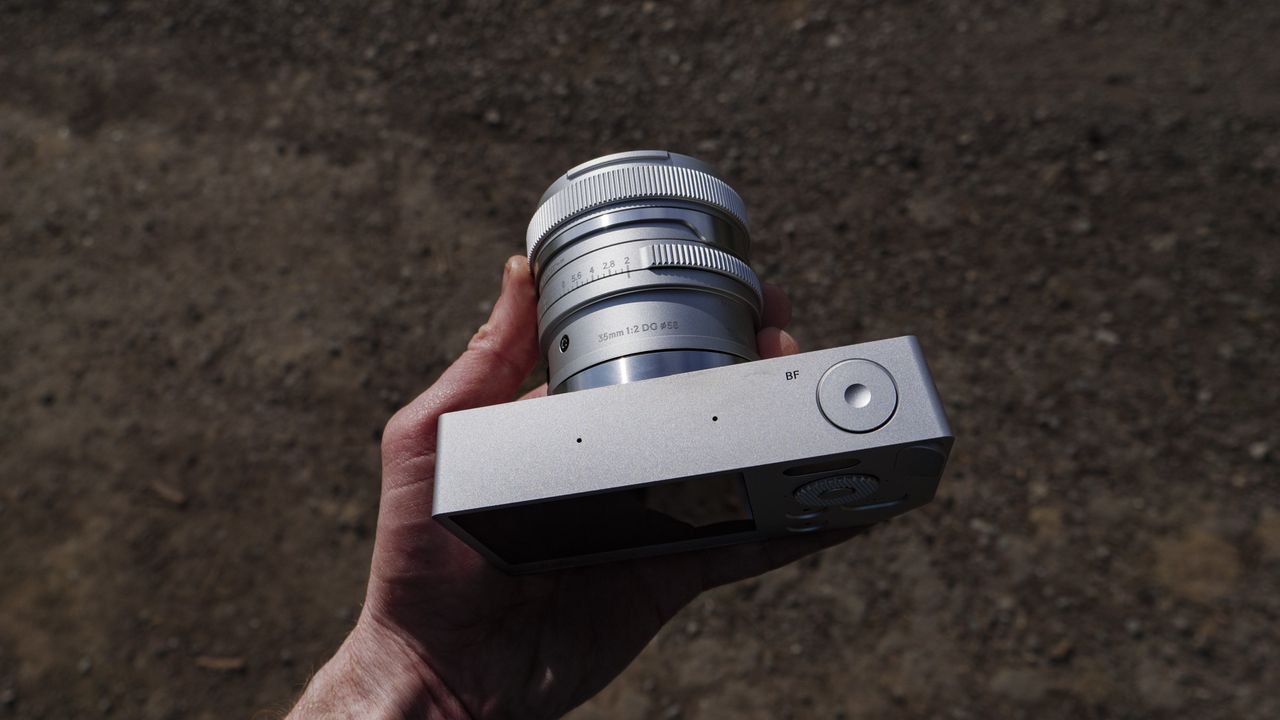 Silver Sigma BF camera with 35mm f/2 DG contemporary lens attached, in the hand