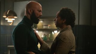 a man and a woman embrace in a dark kitchen